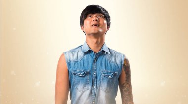 Koyu sarı zemin üzerine ararken Asya yakışıklı adam