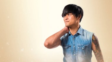 Yakışıklı adamla Asya: boyun ağrısı koyu sarı zemin üzerine