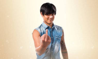 Asya yakışıklı adam yapma boynuz jest koyu sarı zemin üzerine