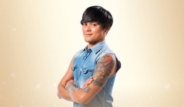 Asya yakışıklı adam kollarını ile koyu sarı arka plan üzerinde çarpı işareti