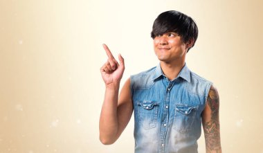 Yukarı dönük ve koyu sarı arka plan üzerinde düşünme Asya yakışıklı adam