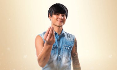 Asya yakışıklı adam yapma para jest koyu sarı zemin üzerine