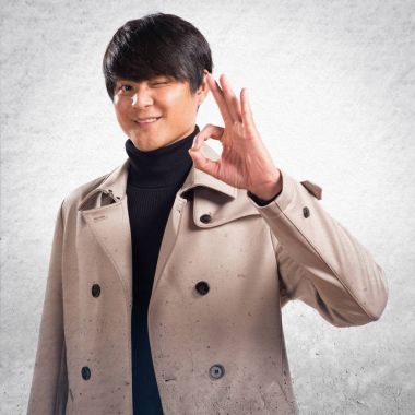 Asya yakışıklı adam Tamam dokulu arka plan üzerinde kayıt yapma