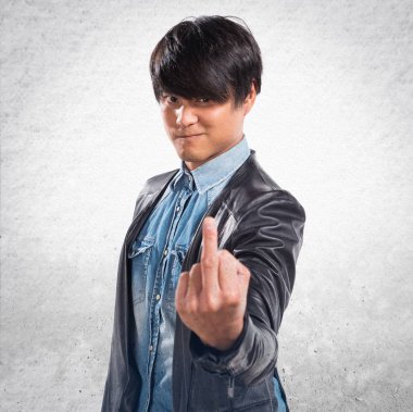 Asya yakışıklı adam yapma boynuz jest dokulu arka plan üzerinde