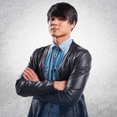 Asya yakışıklı modeli adam Studio dokulu arka plan üzerinde