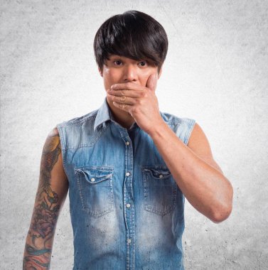 Asya yakışıklı adam ağzını dokulu arka plan üzerinde kapsayan