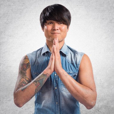 Dokulu arka plan üzerinde yalvaran Asya yakışıklı adam