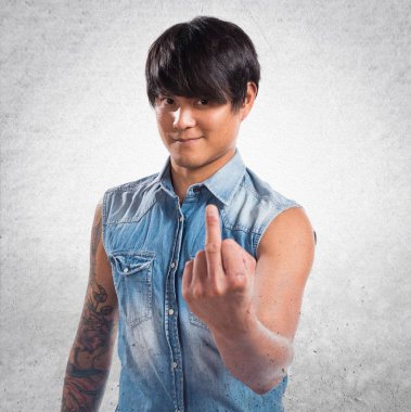 Asya yakışıklı adam yapma boynuz jest dokulu arka plan üzerinde