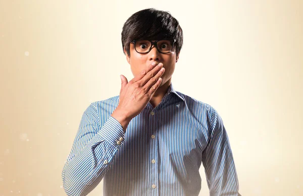 Azjatycka przystojny mężczyzna z okulary podejmowania gest niespodzianka na ochra — Zdjęcie stockowe