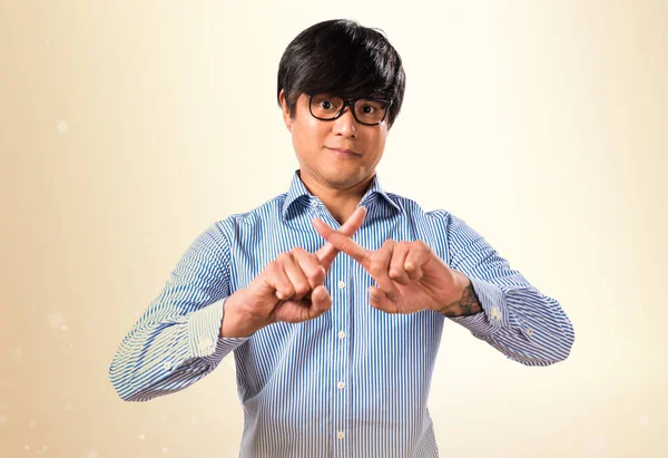 Asiático guapo hombre con gafas haciendo no gesto en ocre espalda — Foto de Stock