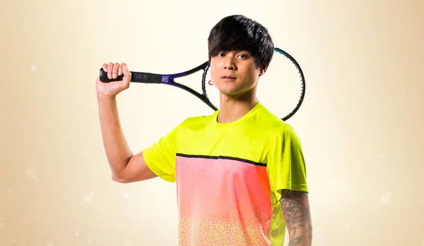 Азиатский теннисист на охерском фоне — стоковое фото
