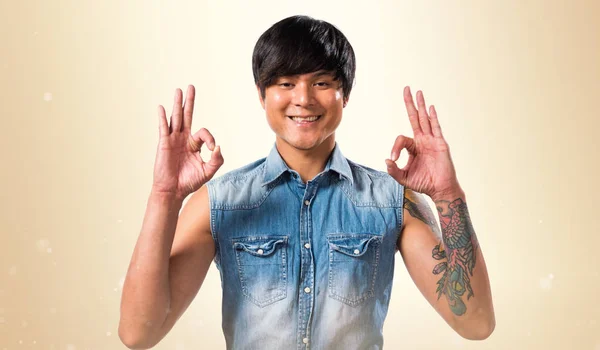 Ázsiai jóképű férfi, így az Ok jel-ra okker háttér — Stock Fotó