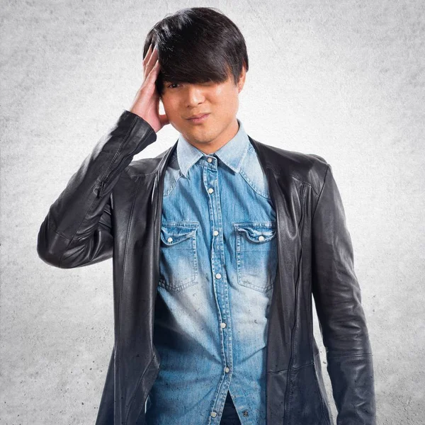 Frustrado asiático guapo hombre en texturizado fondo — Foto de Stock
