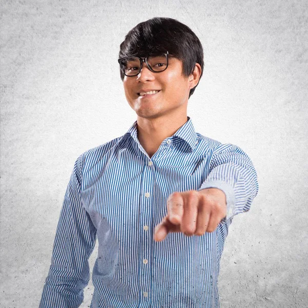 Asiático bonito homem com óculos apontando para a frente na textura — Fotografia de Stock