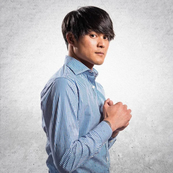 Asiático guapo modelo hombre en estudio en texturizado fondo — Foto de Stock