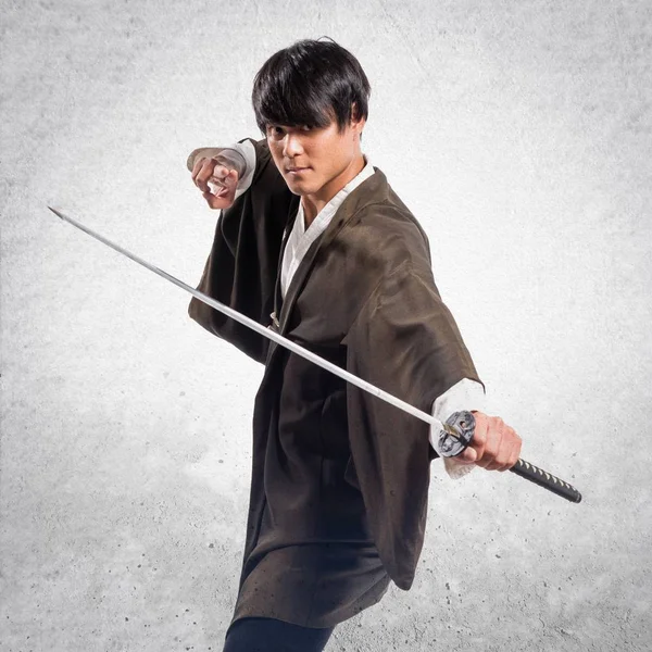 Asiatiska samurai man med katana på texturerat bakgrund — Stockfoto