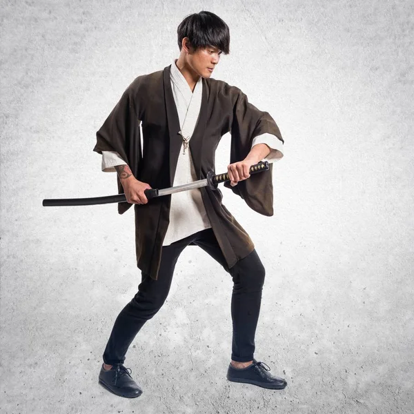 Asiatiska samurai man med katana på texturerat bakgrund — Stockfoto