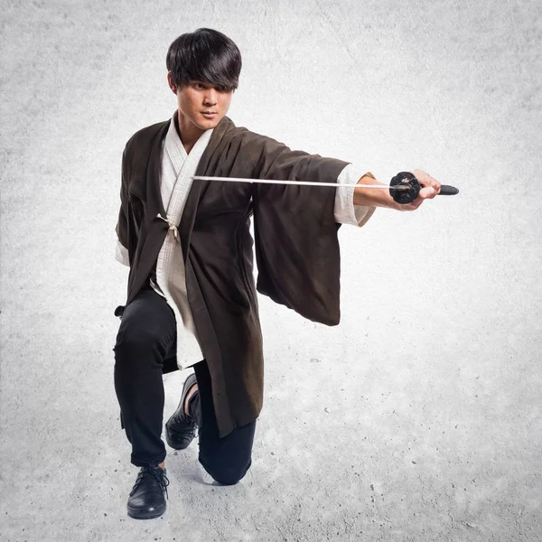 Samurai asiático hombre con katana sobre fondo texturizado —  Fotos de Stock
