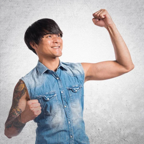 Suerte asiático guapo hombre en texturizado fondo — Foto de Stock