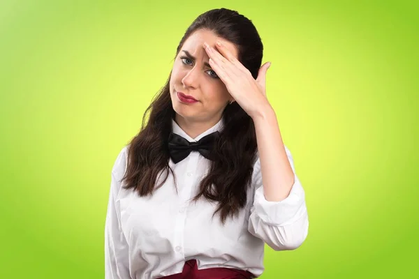 Frustrated young beautiful waitress on colorful background — Stock Photo, Image
