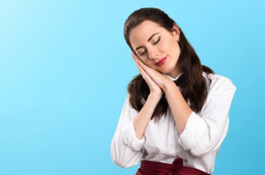 Genç güzel garson yapım uyku jest renkli arka plan üzerinde