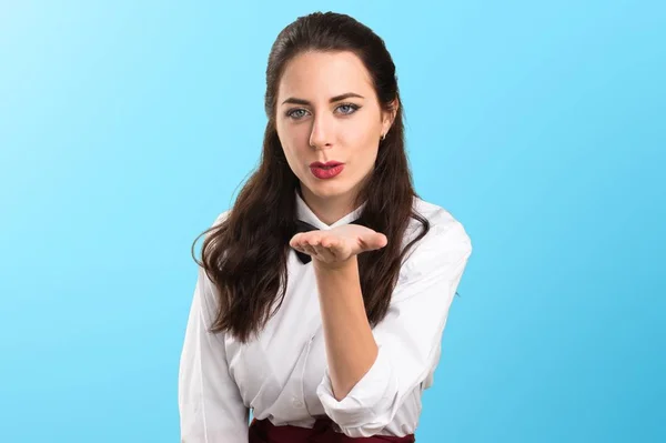 Young beautiful waitress sending a kiss on colorful background — Stock Photo, Image