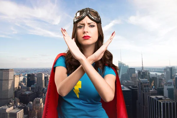 Bastante chica superhéroe haciendo ningún gesto con la ciudad en el fondo — Foto de Stock
