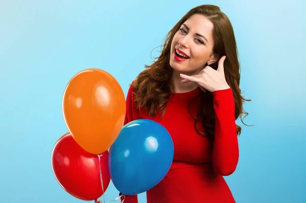 Schönes junges Mädchen hält Luftballons und macht Handygeste auf buntem Hintergrund — Stockfoto