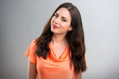 Gri arka plan üzerinde mutlu güzel genç kız