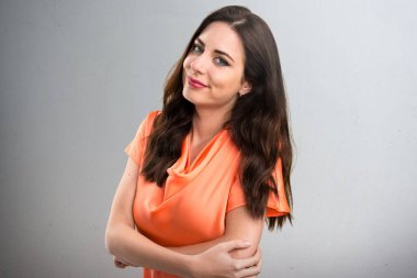 Güzel genç kız gri arka plan üzerinde önemsiz jest yapma