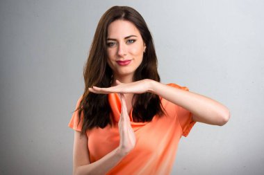 Güzel genç kız verme zaman aşımı jest gri arka plan üzerinde