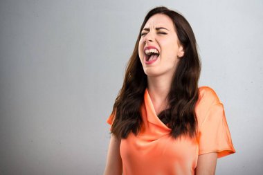 Gri arka plan üzerine bağırarak güzel genç kız