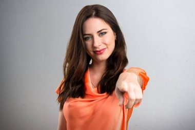 Güzel genç kız açık gri arka plan üzerine işaret