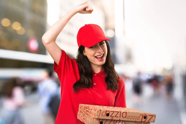 Lucky pizza delivery woman on unfocused background