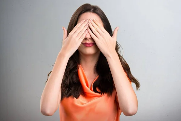 Beautiful young girl covering her eyes on grey background — Stock Photo, Image