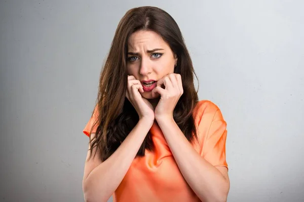 Bang mooie jonge meisje op grijze achtergrond — Stockfoto