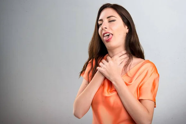 Bella ragazza annegando se stessa su sfondo grigio — Foto Stock