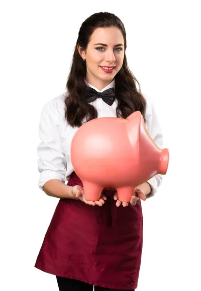 Unga vackra servitris hålla en piggybank Stockfoto