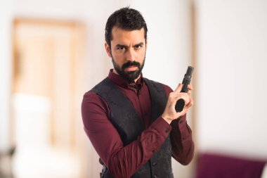 Bir tabanca ile yelek giyen adam 