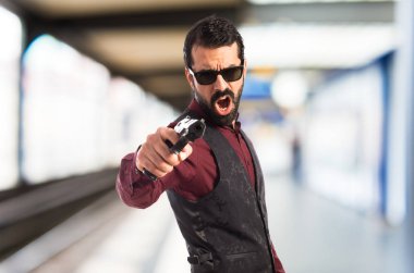 Bir tabanca ile ateş yelek giyen adam 