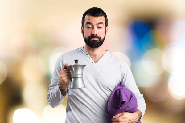 Человек в пижаме держит кофейник — стоковое фото