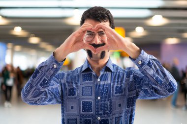 Vintage genç adam elleriyle bir kalp yapma 