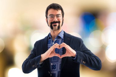 Vintage genç adam elleriyle bir kalp yapma 