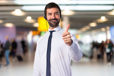 Başparmak ile bir kulaklık ile genç adam