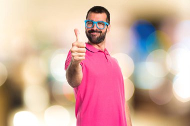 Başparmak ile renkli giysili adam