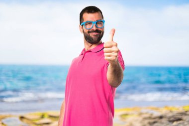 Başparmak ile renkli giysili adam