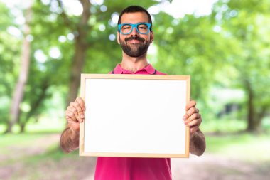 Renkli elbise boş bir afişini tutan adamla