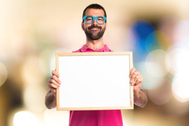 Renkli elbise boş bir afişini tutan adamla