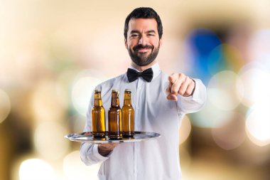 Garson bira şişeleri önüne işaret tepsi ile