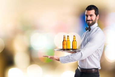 Bira şişe bir şey sunan tepsi ile garson